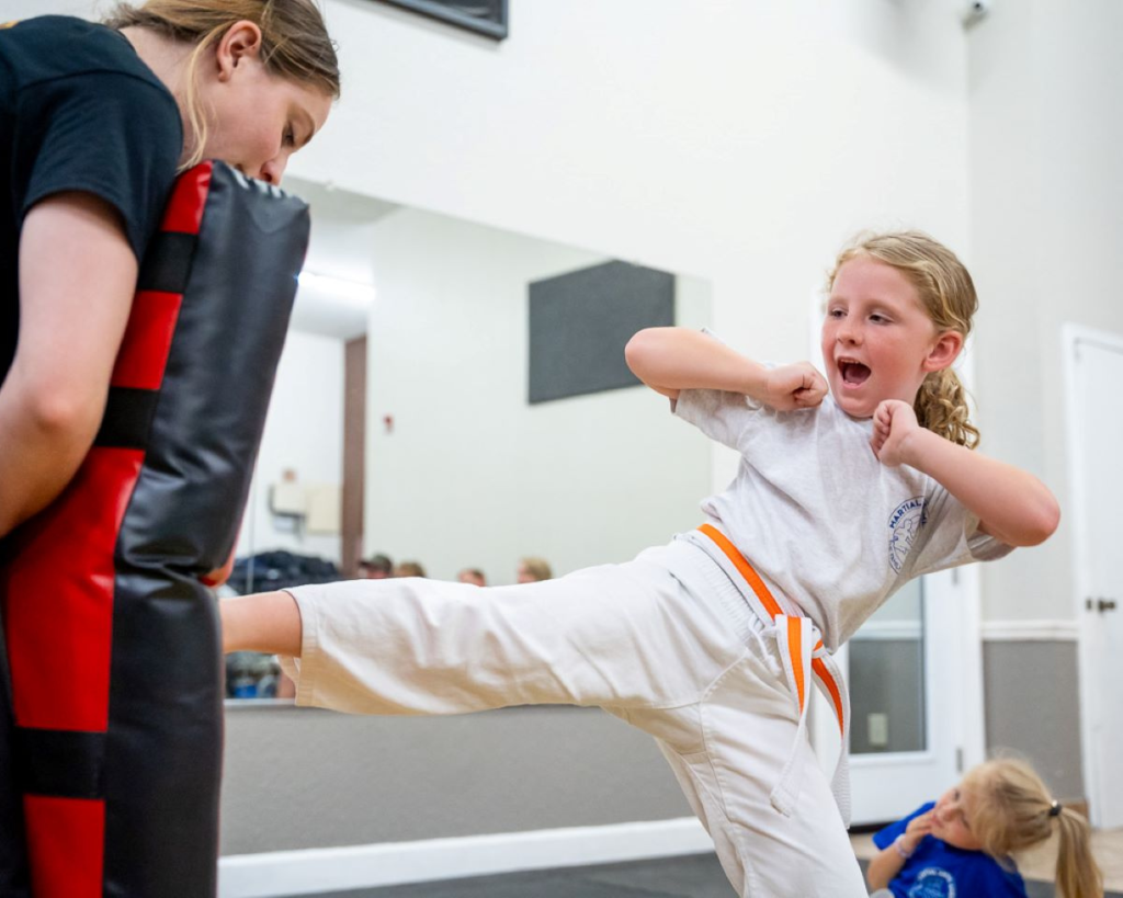 girl in karate uniform kicking